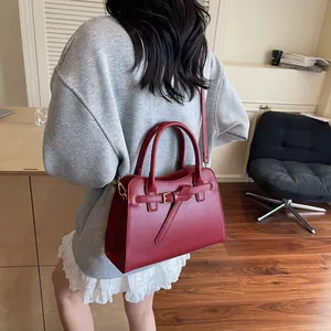 Détail du sac cabas bordeaux avec bandoulières réglables et boucle en métal doré