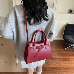 Sac fourre-tout en cuir rouge foncé avec poignées porté par un mannequin en intérieur