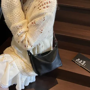 Close-up of black lychee-textured leather hobo bag with silver zipper and wide strap