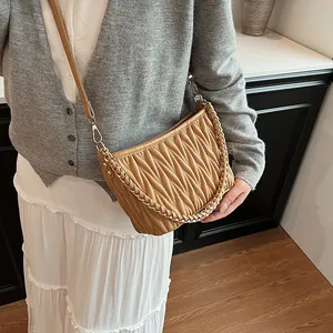 Détail du sac seau plissé kaki avec chaîne tressée et bandoulière en cuir