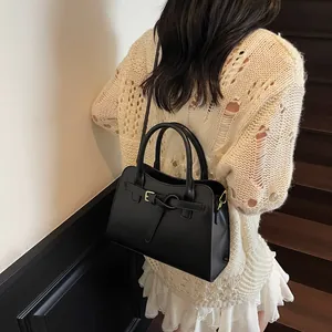 Détail d'un sac cabas noir en cuir porté en bandoulière pour un usage quotidien pratique