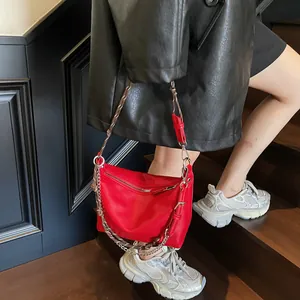 Detail of red crescent bag showing lychee grain leather and silver chain strap system