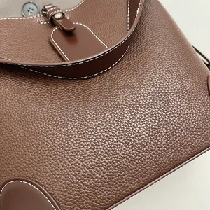 Détails du cuir marron foncé à motif litchi avec des surpiqûres blanches contrastées