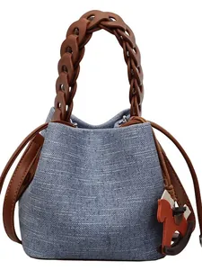 Blue woven bucket bag with chunky brown resin chain and a decorative horse charm