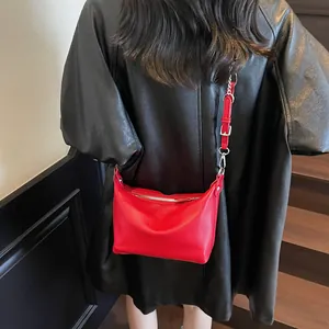 Detailed shot of red lychee textured leather bag with silver metal zippers and buckles