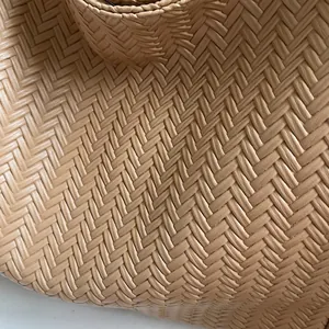 Macro shot of detailed V-shaped woven leather pattern and thick braided handle