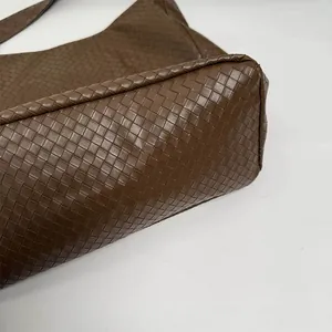 Detailed close-up of dark brown woven Intrecciato texture on large Hobo tote bag