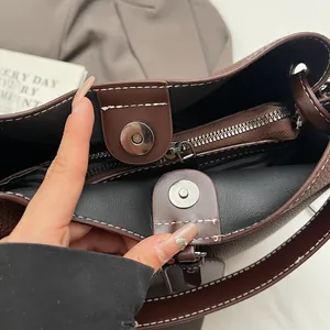 Détail de la fermeture magnétique et de la doublure rayée du sac seau en cuir souple