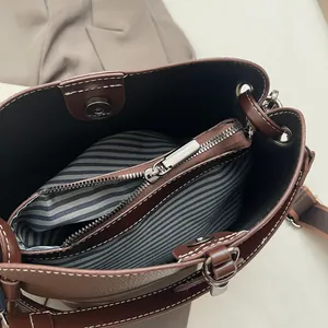 Vue de l'intérieur du sac seau montrant la doublure rayée et le compartiment zippé