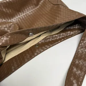 Close-up of brown woven tote bag interior with magnetic closure and zipper pocket