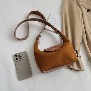 Detailed view of caramel suede hobo bag with adjustable strap and silver metal zipper