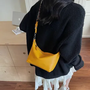 Yellow pebbled leather crossbody bag shown on model wearing black knit and lace skirt