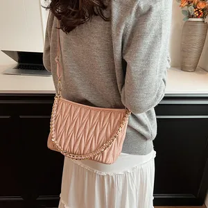 Détail du sac seau en cuir plissé avec chaîne dorée et bandoulière réglable