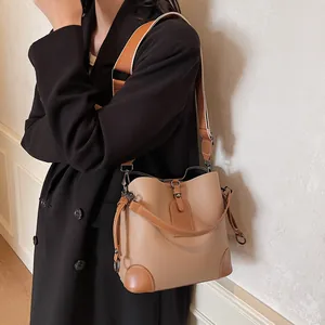 Détail du sac seau kaki avec cuir motif litchi et coins renforcés en cuir marron foncé