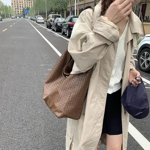 Detailed close-up of dark brown woven leather texture on a large tote bag for women