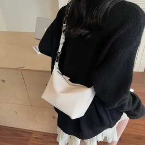 Detail shot of white litchi pattern hobo bag showing the leather texture and strap