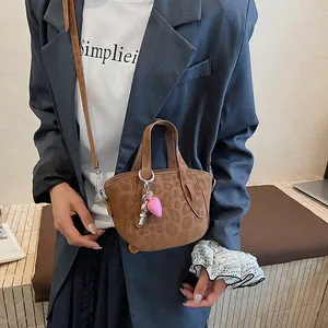Dettaglio della borsa a tracolla vintage leopardata con ciondolo a cuore rosa trendy
