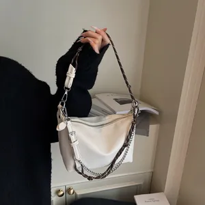 Detail of white lychee leather shoulder bag with woven strap and silver metal chain