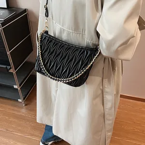 Détail du sac hobo matelassé noir avec texture plissée et bandoulière chaîne dorée