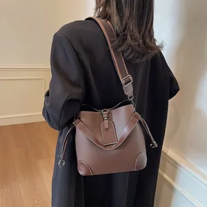 Sac seau en cuir marron avec large bandoulière et coins renforcés pour femme