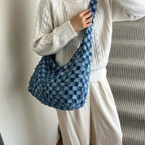 Macro detail of checkerboard denim bag showing frayed edges and texture