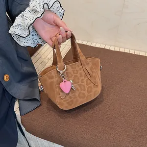 Dettaglio borsa leopardata con ciondolo a cuore rosa e portachiavi a forma di chiave argento