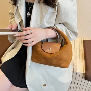 Close-up of vintage brown suede hobo bag with leather flap and metallic snap button