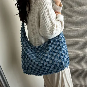 Detail of blue checkerboard denim hobo bag featuring frayed edge texture and large capacity