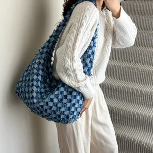 Detail showing blue and white checkerboard denim bag texture with frayed fringe edges