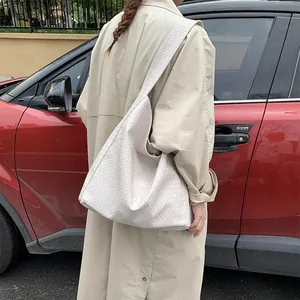 Close-up of cream woven leather hobo bag texture shown during commute with large capacity