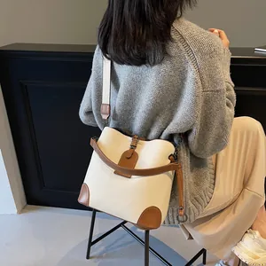 Détail du sac seau crème et marron avec texture litchi et large bandoulière