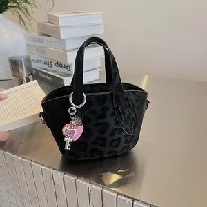Dettaglio della borsa leopardata con ciondoli a cuore rosa e chiave argentata