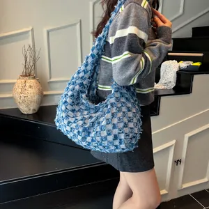 Close-up of vintage denim crossbody bag with blue and white checkerboard pattern and raw edges