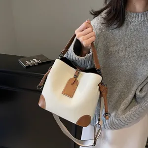 Détails du sac seau en cuir grainé avec garnitures marron et finitions métalliques chic