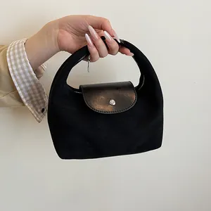 Detail view of the black suede textured hobo bag featuring smooth leather flap and silver buckle