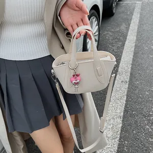 Dettaglio mini borsa tote crema con ciondolo a cuore e chiave in morbida ecopelle liscia