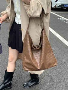 Chic brown woven tote bag for women shown with a stylish trench coat on a city street