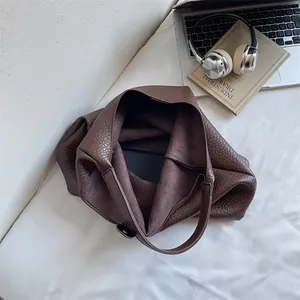 Detailed top view of a large brown tote bag with pebble leather texture and spacious interior