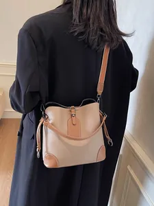 Sac seau élégant en cuir grainé beige avec une large bandoulière réglable chic