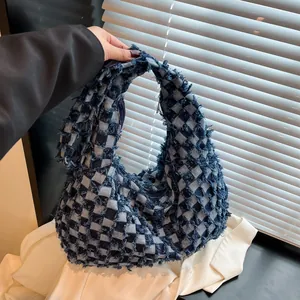 Close-up of checkerboard denim bag showing frayed edges and textured fabric details
