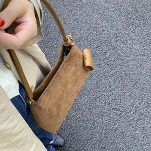 Detailed top view of retro brown shoulder bag with suede texture and leather trim
