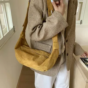 Detail of mustard yellow suede hobo bag featuring premium matte texture and metal zipper