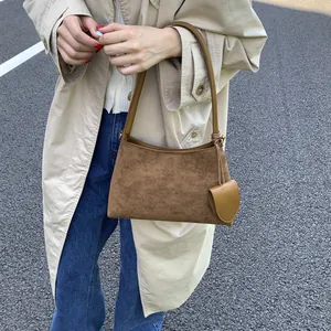 Outdoor street style showing the texture of brown suede on this vintage shoulder bag