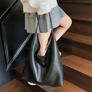 Close-up of black textured leather hobo bag worn on shoulder for daily commute