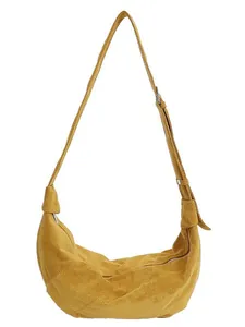 Mustard yellow hobo crossbody bag in matte suede texture with side knot and long strap