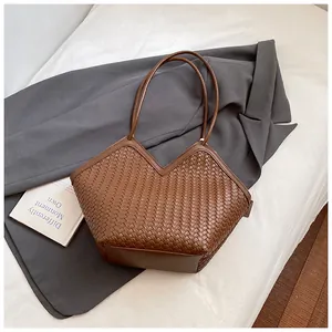 Détail du sac fourre-tout tissé marron avec ouverture en V et texture cuir premium
