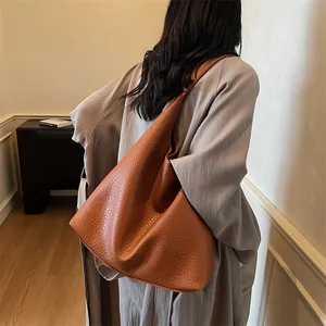 Detail view of brown lychee grain leather tote bag showing texture and large capacity