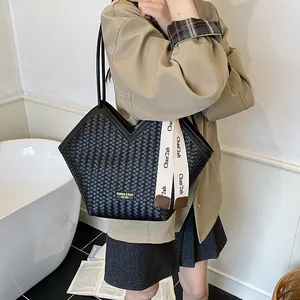 Détail d'un sac cabas noir en cuir PU tressé avec ouverture en V et ruban décoratif élégant