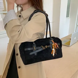 Black frosted Boston handbag with gold hardware and wood bead pendant on trench coat