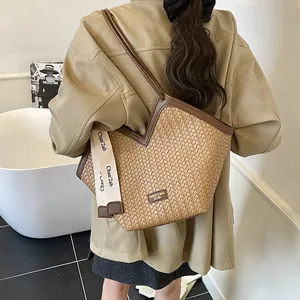 Détail du sac cabas tissé kaki avec bordure en cuir marron et sangle logo tendance